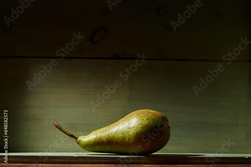 Image of Still Life with a green Pear. Rustic wood background, antique wooden table