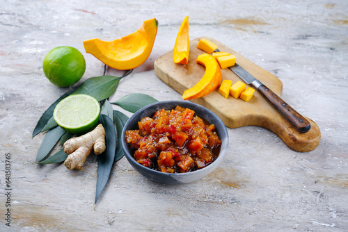 Traditional Indian pumpkin chutney with lemon and ginger served as close-up in a design bowl photo