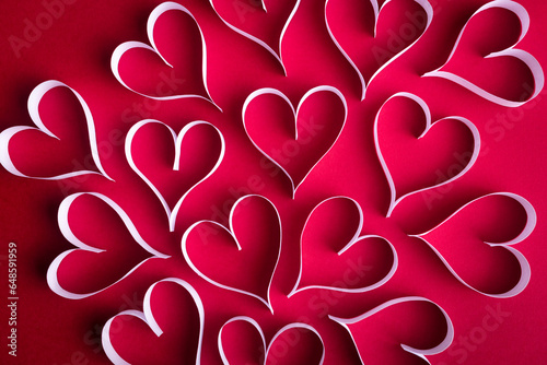 White paper hearts on the red paper background. Valentine background concept.