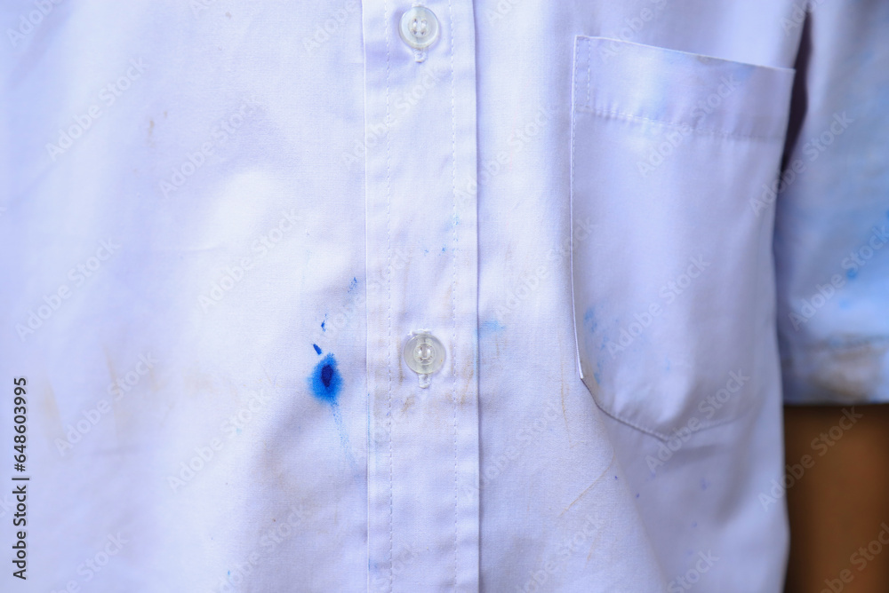 Dirty ink staon on student shirt from using pen in school. dirt stain for cleaning concept. Dirty ink staon on student shirt from using pen in school. dirt stain for cleaning concept.