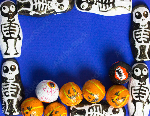 Creative Halloween frame with skeletons, jack o lantern pumpkins with copy space