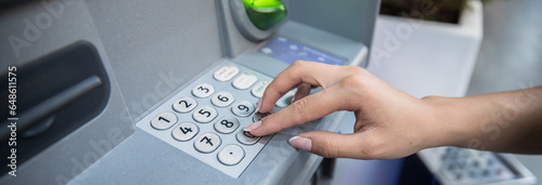Hand entering personal identification number on ATM photo