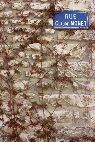 Street signal named after the famous French painter and founder of impressionism, seen as a key precursor to modernism on wall covered with ivy. Giverny France.  photo