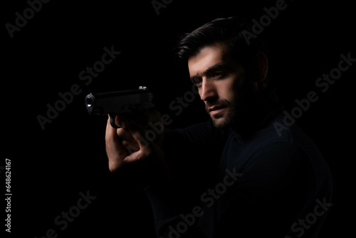 Spy Aiming Gun Undercover police or private detective with a pistol in the dark Young bearded man with gun act like a spy or secret agent Handsome young man pointing gun to outlaw or criminal