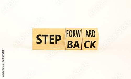 Step back or forward symbol. Concept words Step back Step Forward on wooden cubes. Beautiful white table white background. Businessman hand. Business step back or forward concept. Copy space.