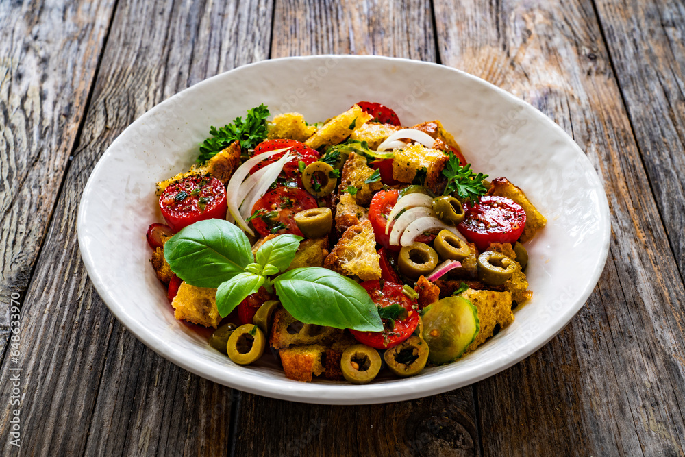Italian style food - panzanella salad on wooden table
