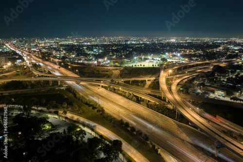 View from above of american big freeway intersection in Miami, Florida at night with fast moving cars and trucks. USA transportation infrastructure concept