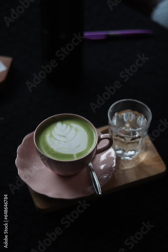 Close up a cup of Matcha green tea Latte art hot drink on wooden table background