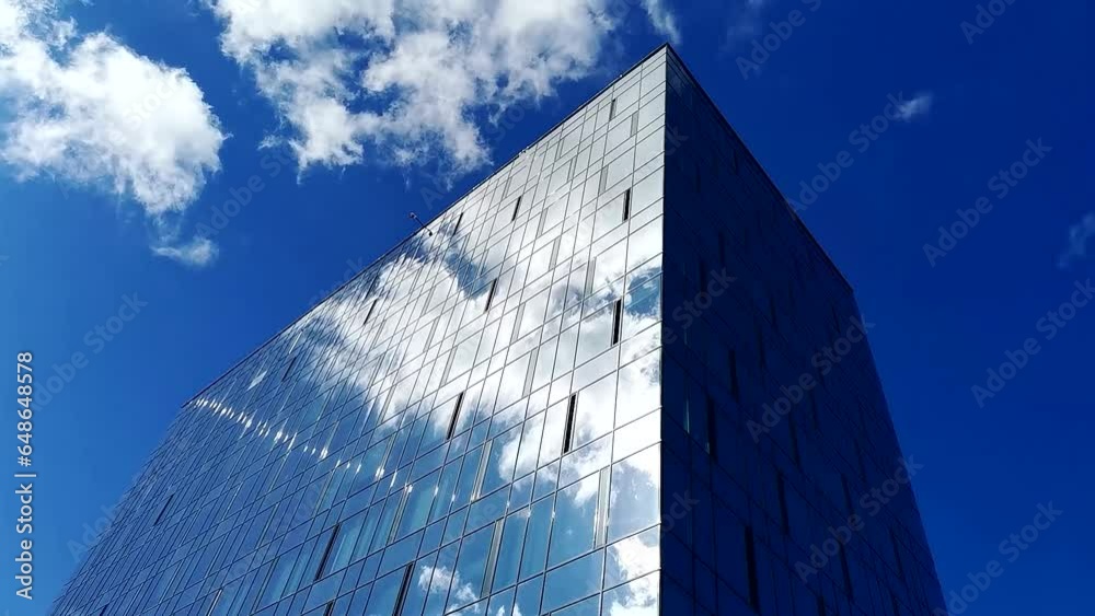 Time lapse of a blue summer sky with clouds reflecting off the glass ...