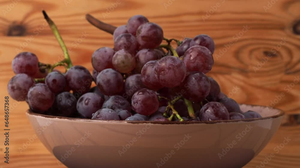 Red grapes rotate on a wooden background. Ripe red grapes. Red grapes rotate on a wooden background. Ripe red grapes.