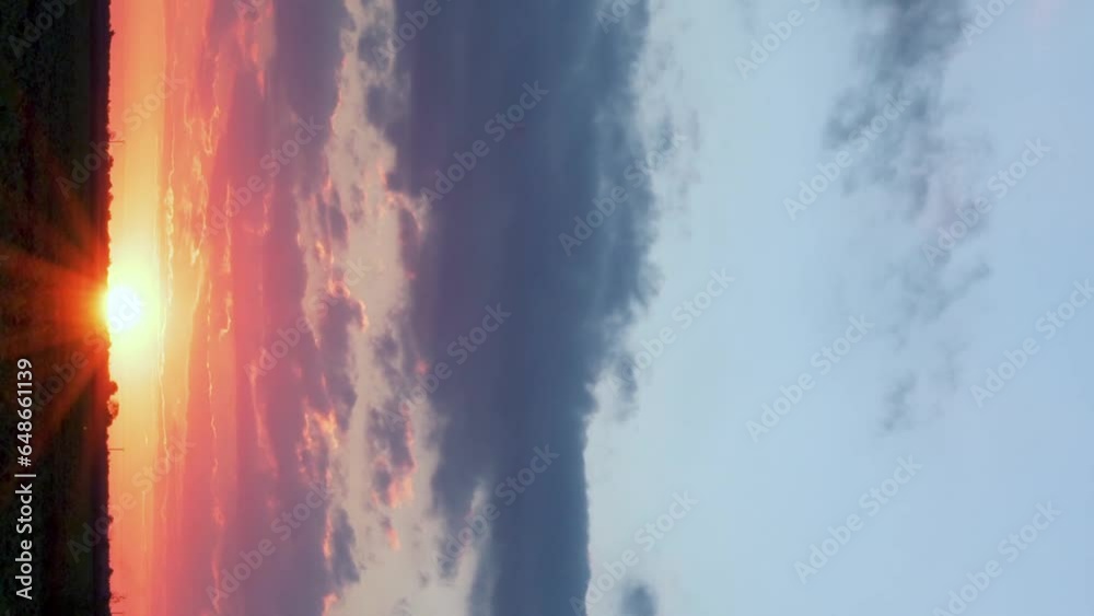 Vertical Footage. Colorful Sunrise Yellow Orange Blue Sky Sun and Clouds over Field. Time Lapse of the Sun Rising from the Horizon in a Rainy Morning Sky with Clouds at Dawn. Beautiful Landscape.
