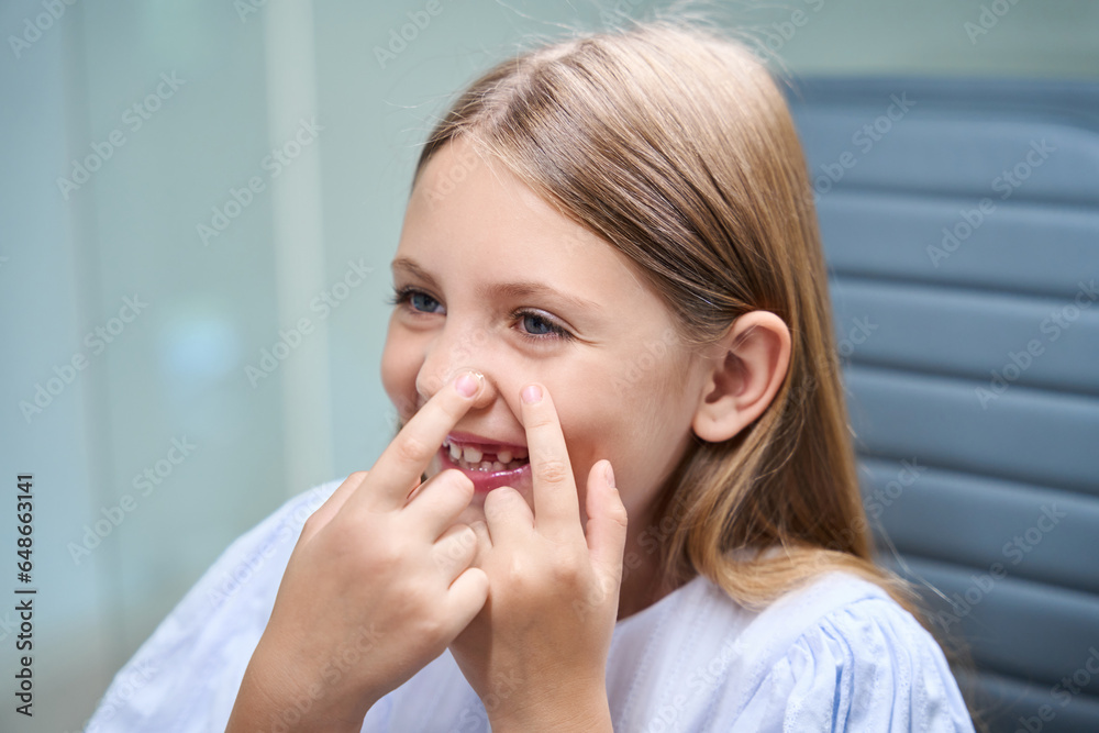 Cheerful pediatric patient learning to put in corrective lenses Cheerful pediatric patient learning to put in corrective lenses