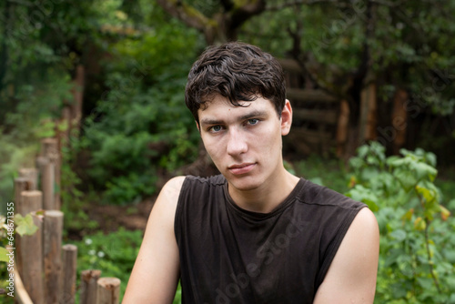 Portrait of a pensive young teenager boy on the background of the forest in nature, the boy thinks, decides how to overcome his teenage problems, depression