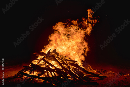 huge bonfire in the night, large wooden logs being burned and flames are blazing away