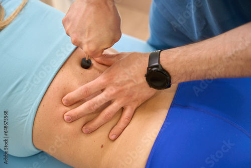 Chiropractor massaging patient's spine, acting on the nerve endings