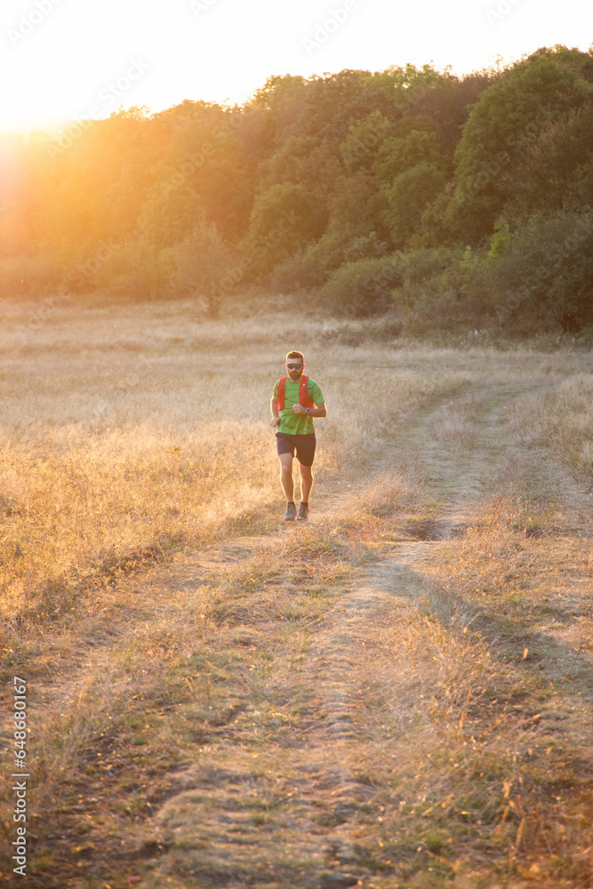 trail runner running at sunset
