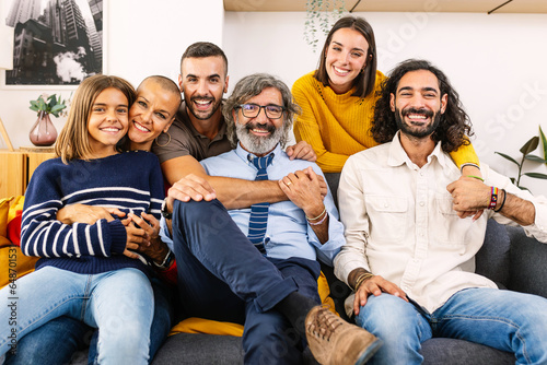 Portrait of big multi generational happy family. Photo group of grandfather, mother, father, aunt, ancle and granddaughter sitting together on sofa at home