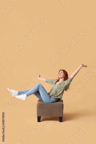 Young woman sitting on pouf...