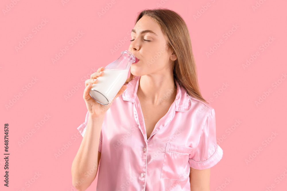 Young woman drinking milk on pink background Young woman drinking milk on pink background