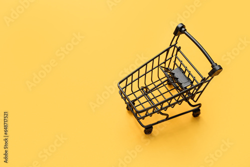 Small shopping cart on yellow background