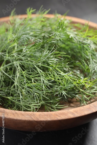 Bowl of fresh dill on grey table, closeup