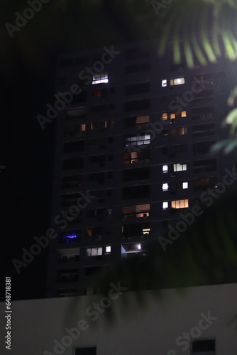 Janelas acesas de um prédio na Barra, a noite