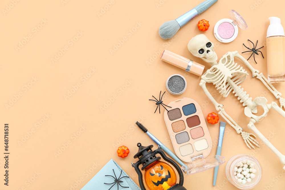 Composition with different makeup products, skeleton, lantern and spiders for Halloween celebration on beige background