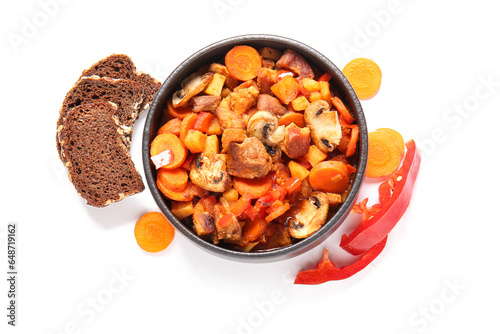 Bowl of tasty beef stew, bread, carrot and bell pepper on white background