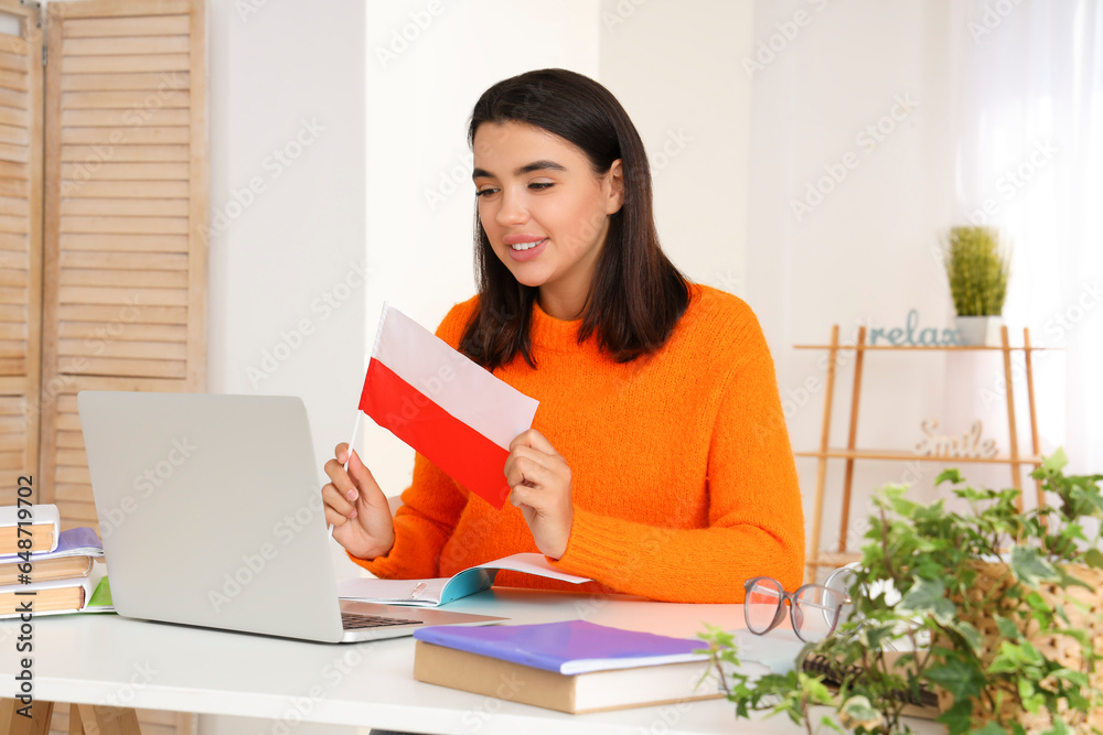 Young woman with flag of Poland learning language online at home Young woman with flag of Poland learning language online at home