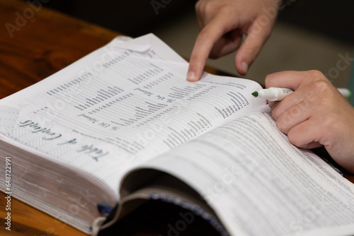 Woman reading Bible during Bible study time in a discipleship group, hands on pages, pointing to verse while reading, close up of verses on page photo