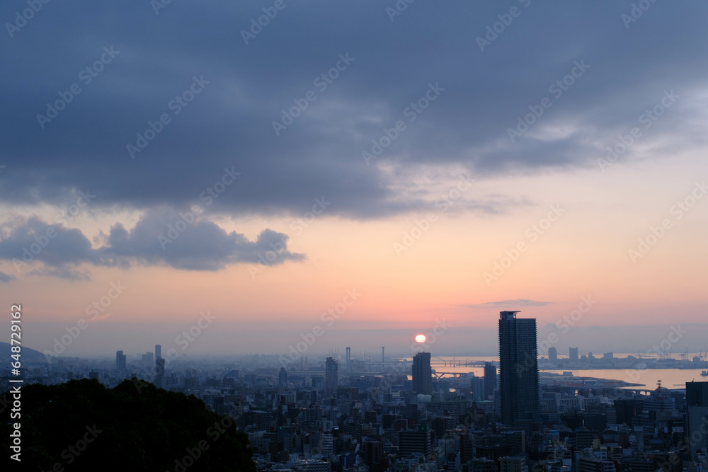 神戸市の高台ヴィーナスブリッジからの夜明け。大阪湾の向こうから太陽が昇りあたりはオレンジ色に染まる。