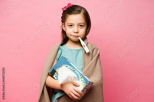 Upset kid sick with a cold and a fever photo