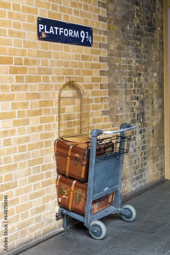 Fototapeta premium London, United Kingdom - 27 July 2016: Platform 9 3/4 photo spot at King's Cross station. Tourists can post photos with the trolley which stuck in the wall