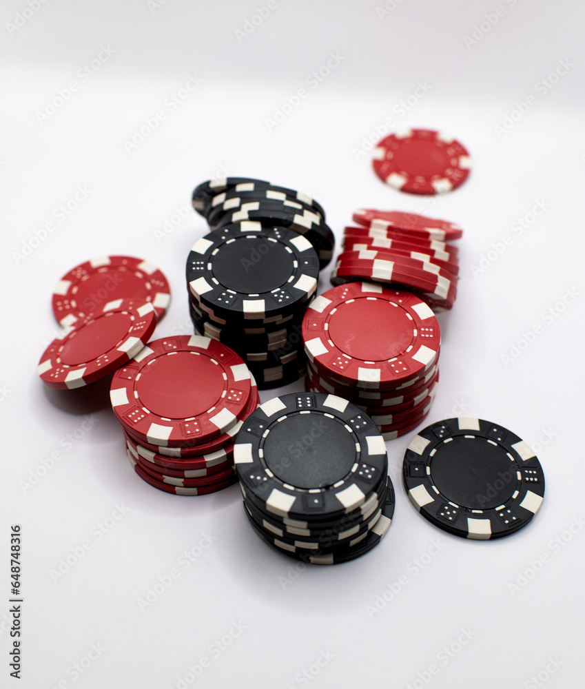 black and red poker chips spilled over on a white background 