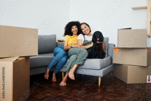 New home, portrait and lesbian couple with a dog on the sofa for moving boxes and relocation. Smile, lgbt and women or people on the living room couch of an apartment with a pet and a homeowner © aLListar/peopleimages.com