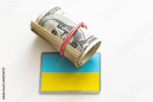 100 dollar banknote and Ukrainian national flag for design pupose photo