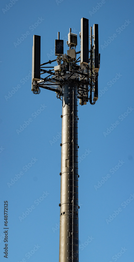 Close up view of a black mobile telecommunication cell tower on a blue sky background Close up view of a black mobile telecommunication cell tower on a blue sky background