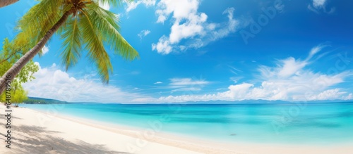 Beautiful tropical beach with white sand, turquoise ocean on background blue sky with clouds on sunny summer day photo