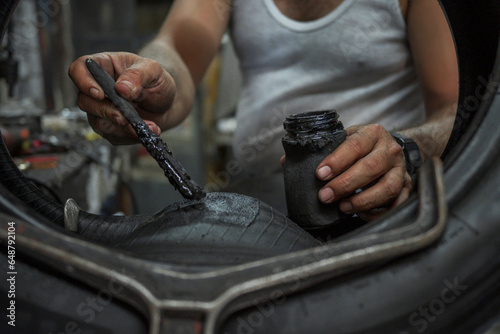 hands of man close up vulcanize a tire to repair it photo