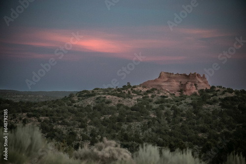 Red glow in the sky above a high desert landscape at dusk photo