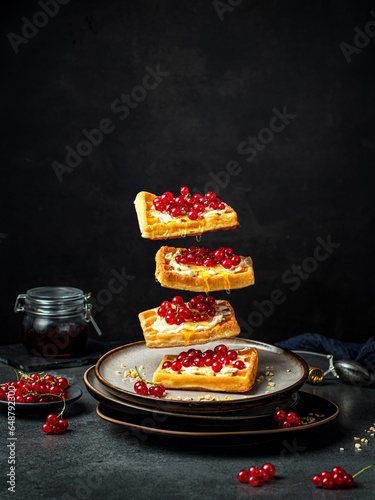 still life with sweet waffles on black table. Food levitation photo