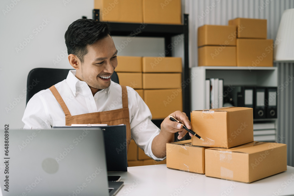 Startup small business entrepreneur or freelance using a laptop with box, checking orders from customers. Startup small business entrepreneur or freelance using a laptop with box, checking orders from customers.