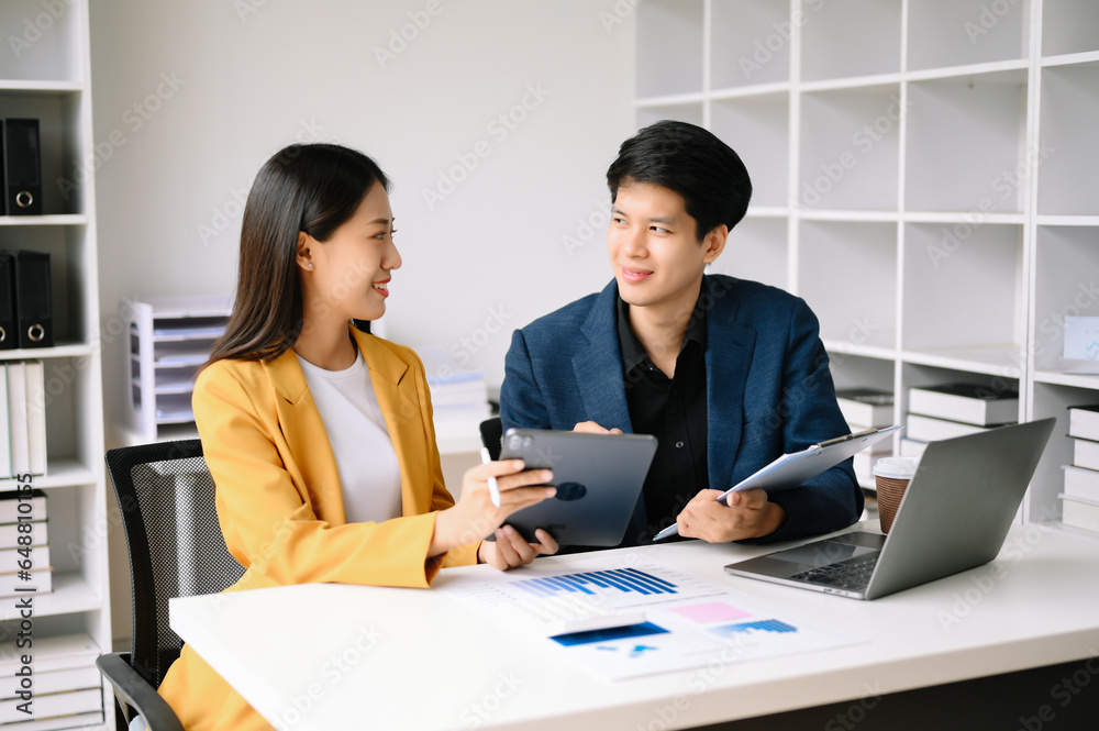 Two Asian business man and woman workers talking on the smartphone and using laptop Professionals in Teamwork Finance, Marketing, and Success Two Asian business man and woman workers talking on the smartphone and using laptop Professionals in Teamwork Finance, Marketing, and Success