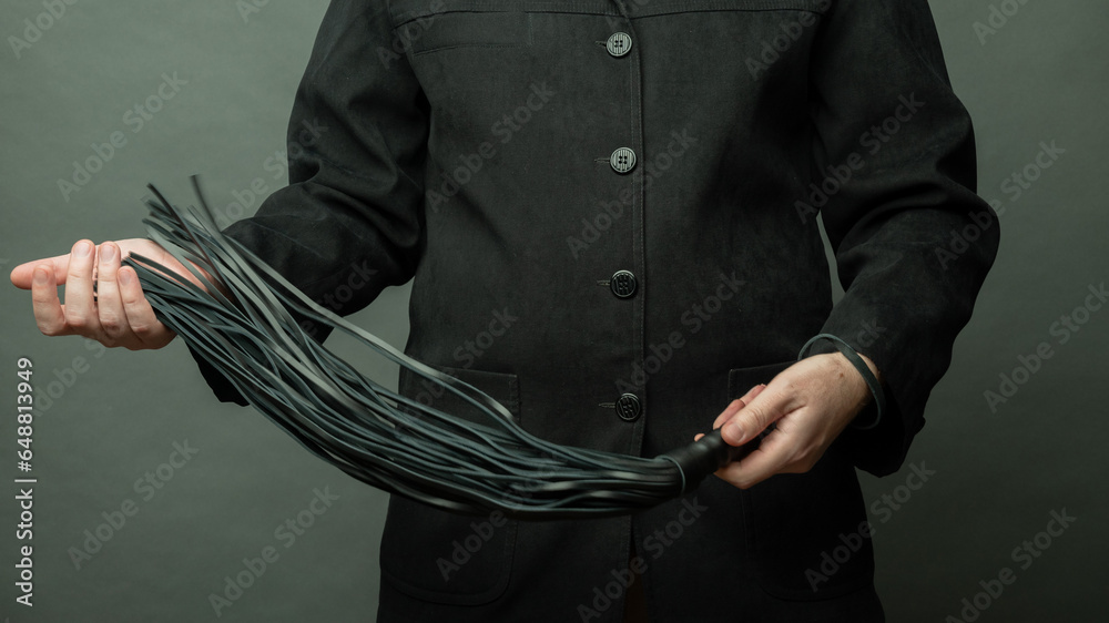 male dominant holds a leather whip Flogger for hard BDSM sex with spanking male dominant holds a leather whip Flogger for hard BDSM sex with spanking