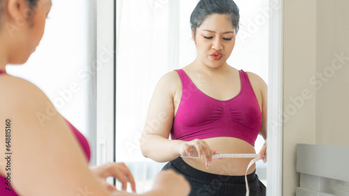 asian fat women , Fat girl , Chubby, overweight plus size looking the mirror measuring her waist in the bedroom - lifestyle Woman diet weight loss overweight problem concept