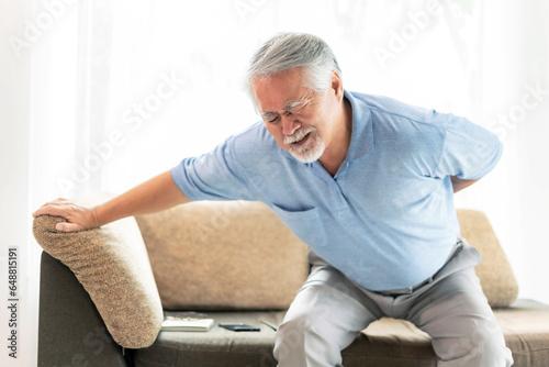 Elderly patients on couch , Asian senior man suffering from back pain - medical and healthcare concept
