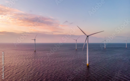Sunset at Windmill Park in the ocean aerial view with wind turbine Flevoland Netherlands Ijsselmeer. Green Energy Production in the Netherlands