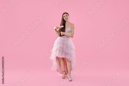 Woman wearing high heeled shoe and sneaker on pink background. Glamour vs comfort