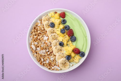 Fototapeta Naklejka Na Ścianę i Meble -  Tasty matcha smoothie bowl served with fresh fruits and oatmeal on violet background, top view. Healthy breakfast
