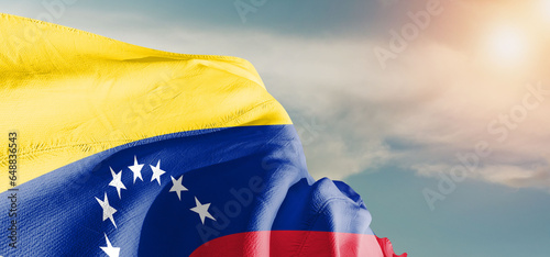 Venezuela national flag cloth fabric waving on beautiful sky Background.
